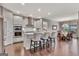 Modern kitchen featuring white cabinetry, stainless steel appliances, and a breakfast bar, and view to dining area at 411 Southbridge Pass, Peachtree City, GA 30269