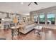 Spacious living room featuring hardwood floors, large windows, and flowing into the kitchen and dining areas at 411 Southbridge Pass, Peachtree City, GA 30269
