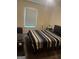 Simple bedroom with a queen bed, modern striped bedding, a fan and bright natural light, providing a restful space at 1063 Nw Cato Nw St, Atlanta, GA 30318