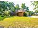 Exterior view of brick home featuring a garage, lush greenery, and mature trees at 195 Youngs Cir, Fayetteville, GA 30215