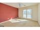 Bedroom with neutral carpet, a window, ceiling fan and salmon accent wall at 195 Youngs Cir, Fayetteville, GA 30215