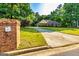 Long driveway leading to a charming brick home with manicured lawns and mature trees at 195 Youngs Cir, Fayetteville, GA 30215