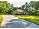 Long driveway leading to an attached garage and a beautiful brick home surrounded by lush greenery at 195 Youngs Cir, Fayetteville, GA 30215