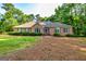 Charming brick home featuring well-maintained landscaping, arched window, and mature trees at 195 Youngs Cir, Fayetteville, GA 30215