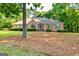 Charming brick home featuring well-maintained landscaping, arched window, and mature trees at 195 Youngs Cir, Fayetteville, GA 30215