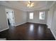 Bright bedroom features wood floors, two windows, a ceiling fan, and a view into the bathroom at 1204 Bent Creek Dr, Mcdonough, GA 30252