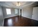 Bedroom featuring hardwood floors, two windows, and recessed ceiling with a ceiling fan at 1204 Bent Creek Dr, Mcdonough, GA 30252