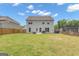 Large grassy backyard with wooden fence and view of back of home at 206 Roundwood Way, Peachtree City, GA 30269