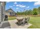 View of the backyard patio with a dining table and a trampoline in the large lawn at 206 Roundwood Way, Peachtree City, GA 30269