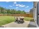Open backyard patio with an outdoor dining table and a large lawn at 206 Roundwood Way, Peachtree City, GA 30269