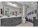 Modern bathroom featuring a double vanity with gray cabinets and neutral wall and floor tiles at 206 Roundwood Way, Peachtree City, GA 30269