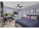 Bedroom with blue walls featuring a gaming setup, ceiling fan, and a window view at 206 Roundwood Way, Peachtree City, GA 30269