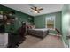 Bedroom featuring a gray bed, green walls, carpeted floors and a wooden ceiling fan at 206 Roundwood Way, Peachtree City, GA 30269
