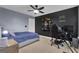 A bedroom with a gaming setup, decorated with a dark accent wall and neutral carpet at 206 Roundwood Way, Peachtree City, GA 30269