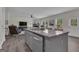 Open kitchen with gray island, stainless steel appliances, and a seamless view to the living area at 206 Roundwood Way, Peachtree City, GA 30269