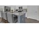 Close-up of the kitchen island with stone countertops and modern bar stool seating at 206 Roundwood Way, Peachtree City, GA 30269