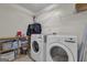 Well-lit laundry room featuring modern washer and dryer with wooden shelving at 206 Roundwood Way, Peachtree City, GA 30269