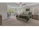 Spacious main bedroom with neutral carpet, ceiling fan, and a home office by the window at 206 Roundwood Way, Peachtree City, GA 30269