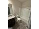 Well-lit bathroom with vanity, granite counter, toilet, and tub/shower combo at 442 Snow Owl Way, Lawrenceville, GA 30044