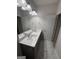 A well-lit bathroom featuring a dual sink vanity, a large mirror, and stylish fixtures at 442 Snow Owl Way, Lawrenceville, GA 30044