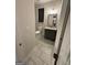 A modern half bathroom featuring a gray vanity, granite countertop, and neutral tile flooring at 442 Snow Owl Way, Lawrenceville, GA 30044