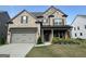 Beautiful two-story home with a stone and brick facade, well-maintained lawn, and covered entryway at 442 Snow Owl Way, Lawrenceville, GA 30044