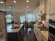 Open kitchen with a large island, white cabinetry, stainless steel appliances, and a view to the breakfast nook at 442 Snow Owl Way, Lawrenceville, GA 30044