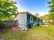 Backyard of a blue home with a wooden fence and green grass at 1183 Iron Gate Blvd, Jonesboro, GA 30238
