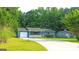 Welcoming home with a blue exterior, a one-car garage, trimmed shrubs, and a lush green lawn at 1183 Iron Gate Blvd, Jonesboro, GA 30238