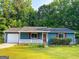 Charming blue single-story home with red shutters, attached garage, and flourishing front yard at 1183 Iron Gate Blvd, Jonesboro, GA 30238