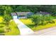 Inviting home with a long driveway, white-trimmed porch, manicured lawn, and mature trees at 1183 Iron Gate Blvd, Jonesboro, GA 30238