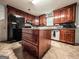 Well-lit kitchen featuring wood cabinets, island with drawers, and black refrigerator at 1183 Iron Gate Blvd, Jonesboro, GA 30238