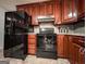 Kitchen with a black refrigerator, oven, and wood cabinets at 1183 Iron Gate Blvd, Jonesboro, GA 30238
