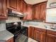 Fully-equipped kitchen featuring dark wood cabinets, and modern appliances at 1183 Iron Gate Blvd, Jonesboro, GA 30238