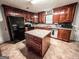 Traditional kitchen featuring an island, wooden cabinets, and tile flooring at 1183 Iron Gate Blvd, Jonesboro, GA 30238