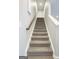 Carpeted stairway with white trim and a wooden handrail leading to the upper level of the home at 1317 Rosemary Ln # 65, East Point, GA 30344