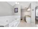 Bright bathroom with a soaking tub, a vanity with granite counters, and contemporary light fixtures at 407 Calgary Dr, Peachtree City, GA 30269