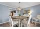 Dining room with modern lighting fixture, wood table, and a view to the living room at 407 Calgary Dr, Peachtree City, GA 30269