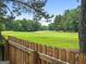 Scenic golf course view beyond a rustic wooden fence and lush greenery at 407 Calgary Dr, Peachtree City, GA 30269