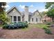 Back of house with porch, patio, lawn, flowering bushes, and a wooded backdrop at 795 Lake Medlock, Alpharetta, GA 30022