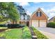 Charming brick home featuring a well-manicured lawn and two-car garage at 795 Lake Medlock, Alpharetta, GA 30022