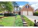 Charming brick home featuring a well-manicured lawn and two-car garage at 795 Lake Medlock, Alpharetta, GA 30022