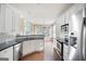 Well-lit kitchen with stainless steel appliances, granite countertops, white cabinetry, and hardwood flooring at 795 Lake Medlock, Alpharetta, GA 30022