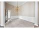 Bright living room with plush carpeting, wainscoting, and a elegant chandelier at 795 Lake Medlock, Alpharetta, GA 30022