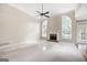 Bright living room featuring a brick fireplace, large windows, plush carpeting, and a ceiling fan at 795 Lake Medlock, Alpharetta, GA 30022