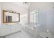 Elegant main bathroom featuring double sinks, soaking tub, glass enclosed shower, and tiled floors at 795 Lake Medlock, Alpharetta, GA 30022
