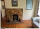 A classic stone fireplace serves as a focal point in a room with hardwood floors and cream-colored walls at 5094 Covington Hwy, Decatur, GA 30035
