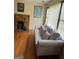 Cozy living room with a stone fireplace, a comfortable couch, and natural light illuminating the hardwood floors at 5094 Covington Hwy, Decatur, GA 30035