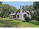 Beautifully landscaped front yard featuring lush lawn and mature trees surrounding the white brick home at 130 Emerald Dr, Mcdonough, GA 30253