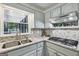 This kitchen includes a stainless steel sink, tile backsplash, and stone countertops at 130 Emerald Dr, Mcdonough, GA 30253